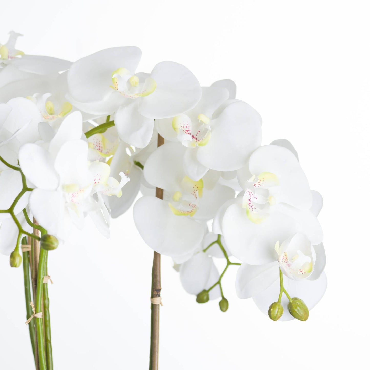 A large faux white Orchid in a stone pot 