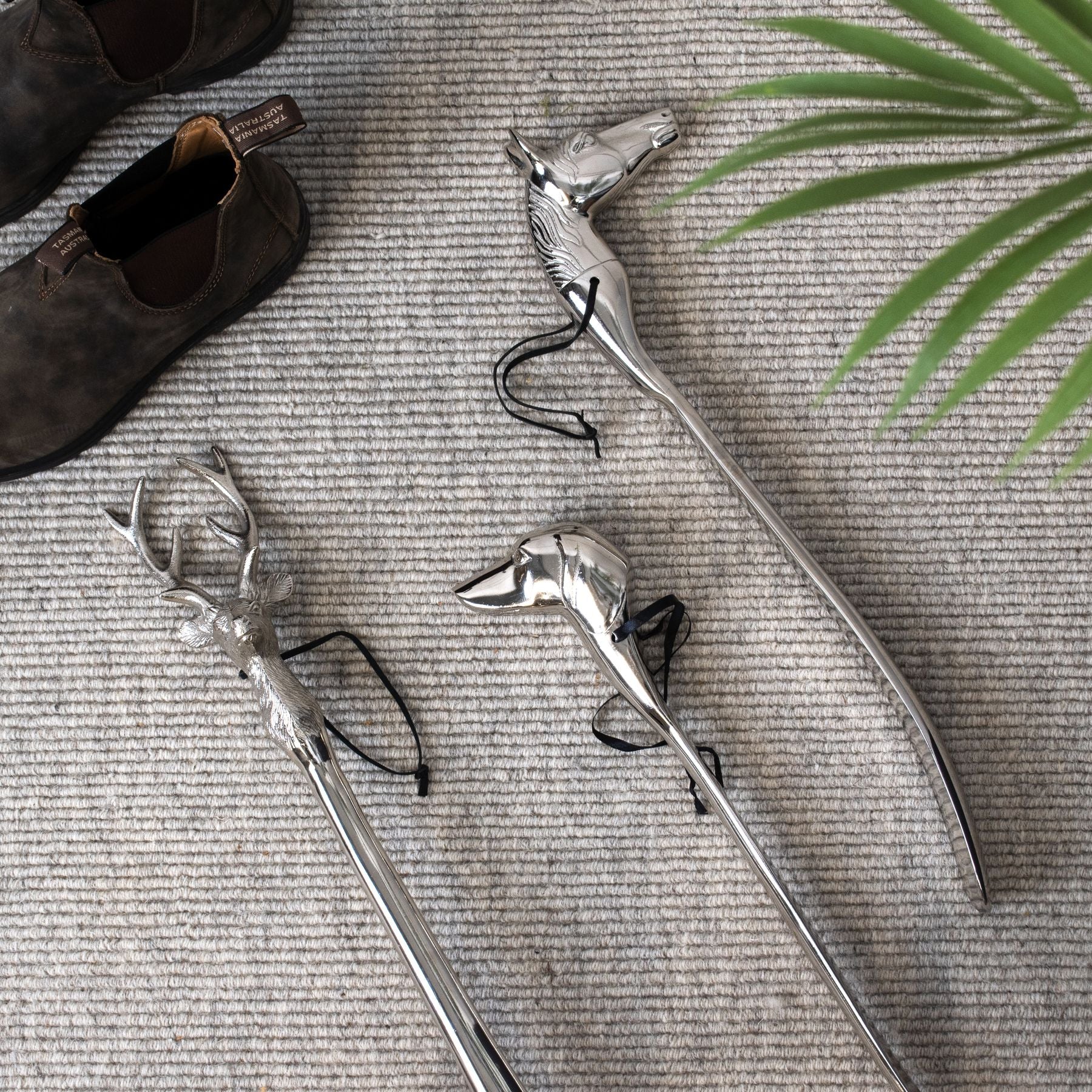 Collection of three nickel shoe horns with different animal heads as handles including stag, dog and horse