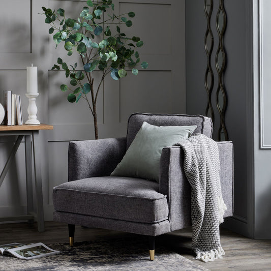 Grey armchair with cushion and blanket