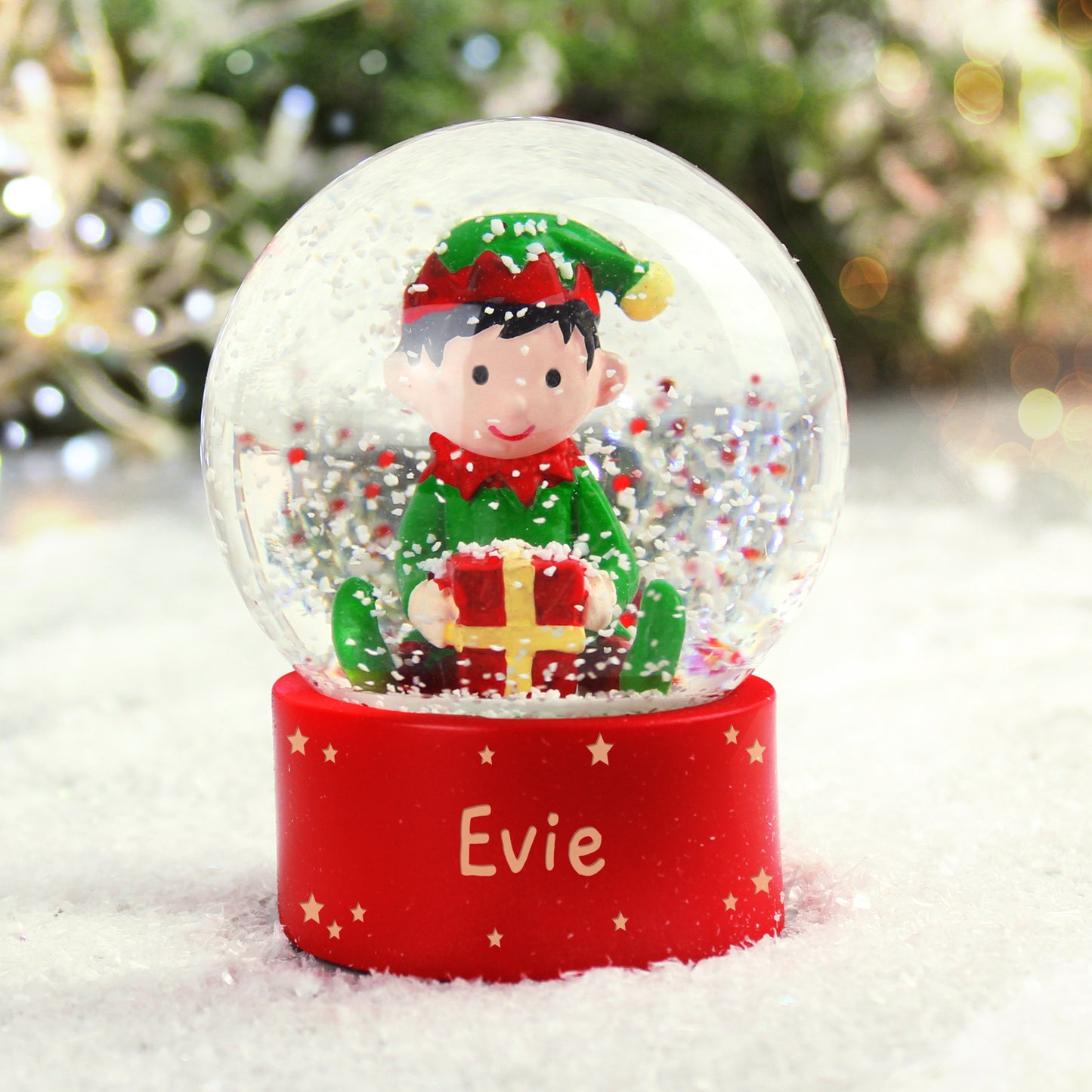 A Christmas snowglobe with a red base that can be personalised with a name and the globe has an elf holding a present inside it