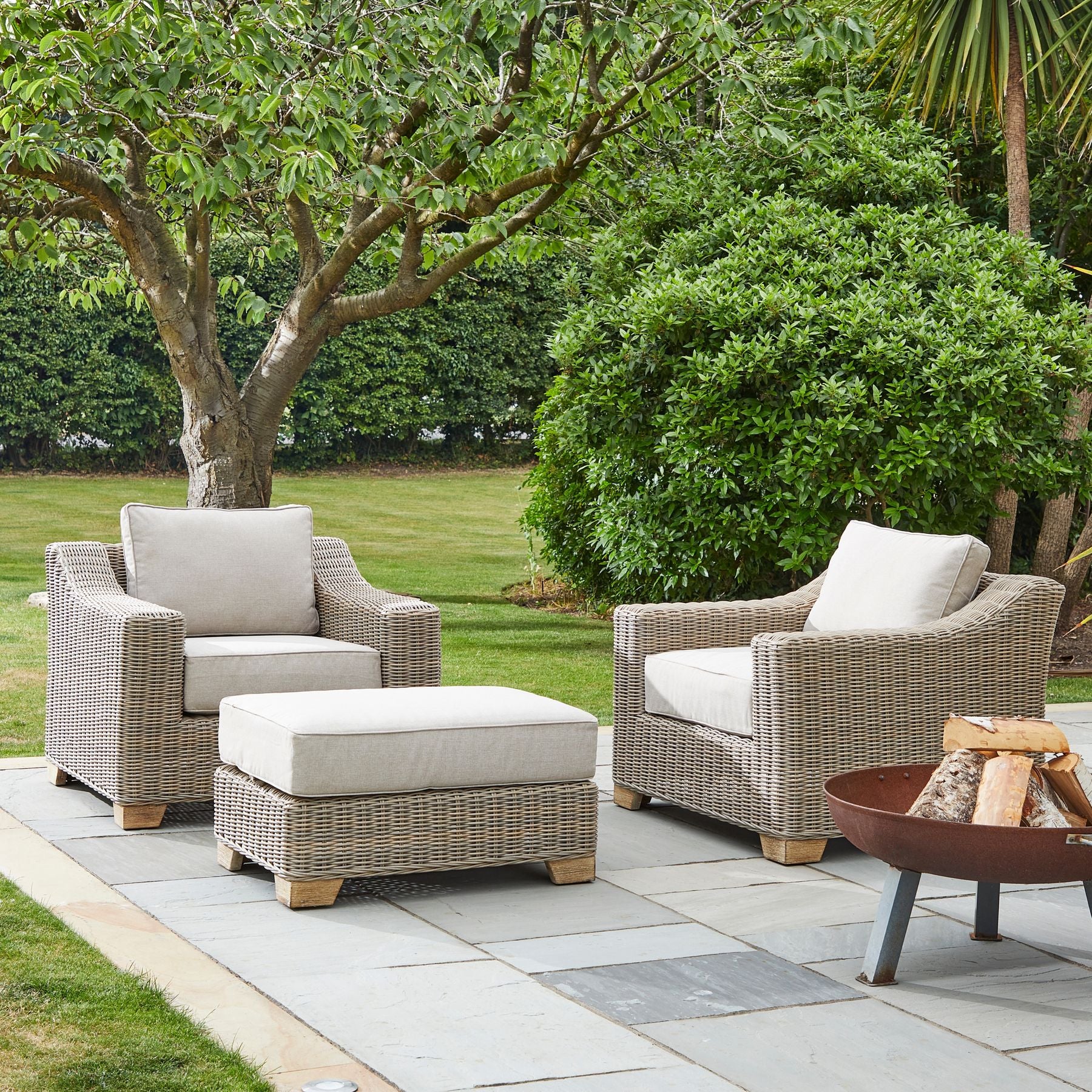 Wicker outdoor armchair with cream cushions