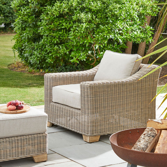 Wicker outdoor armchair with cream cushions
