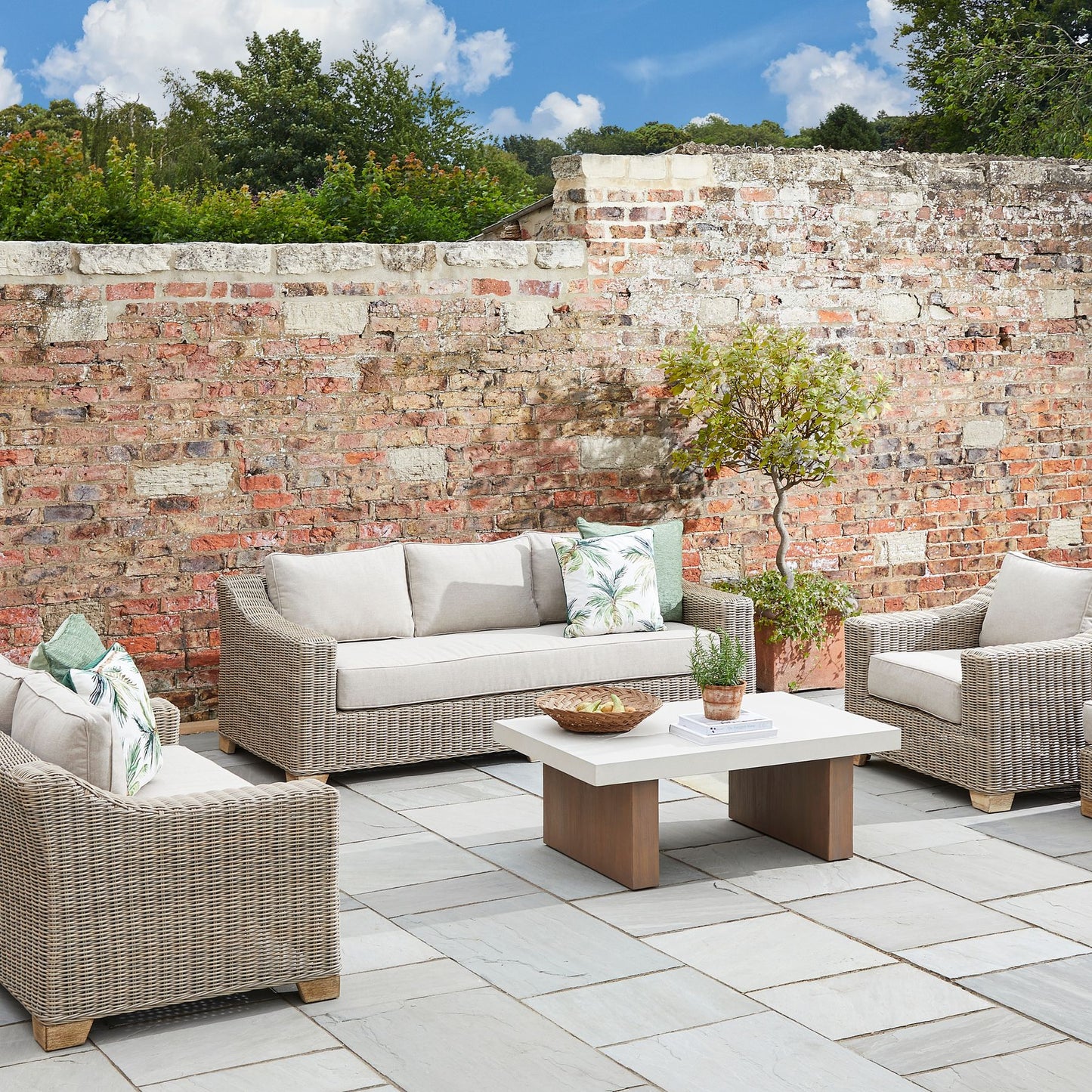 Wicker style outdoor sofa with cream cushions