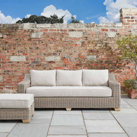 Wicker style outdoor sofa with cream cushions