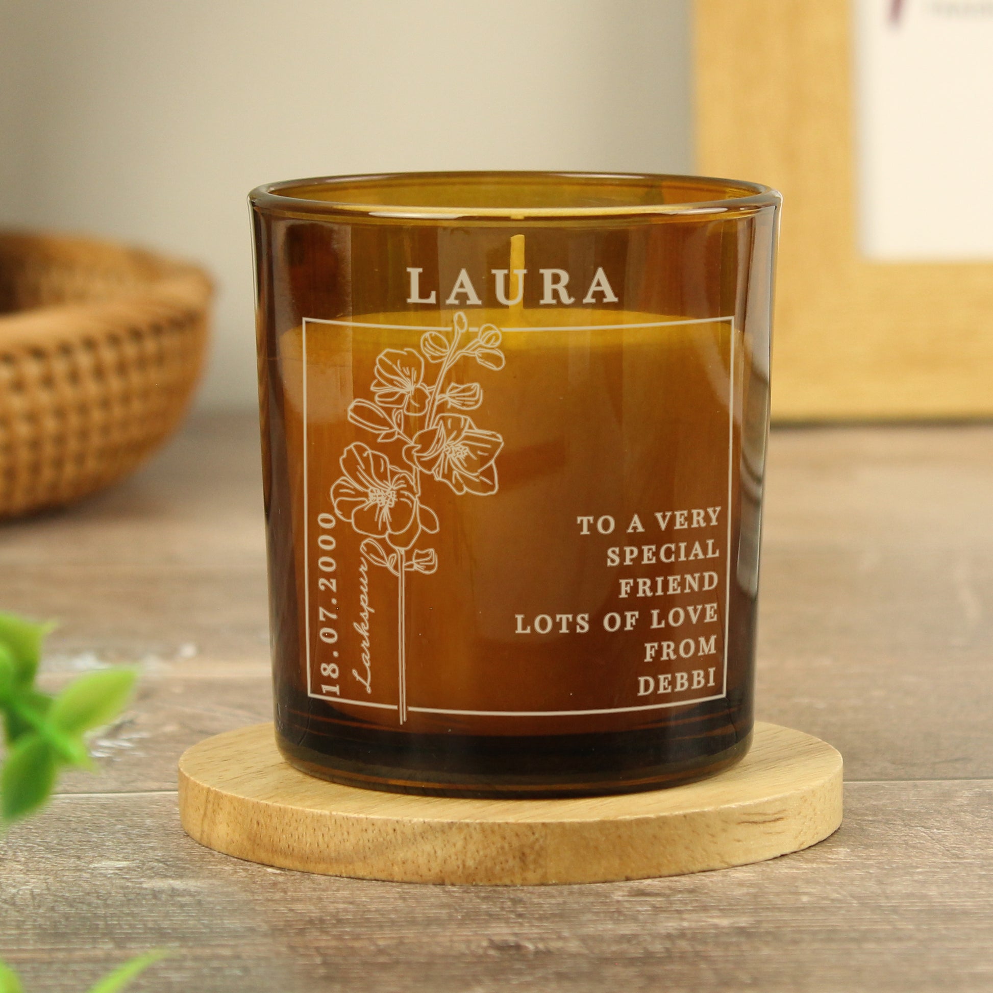 Candle in an amber colour glass container and label with a picture of July’s Birth Flower and space for a personalised name and message 