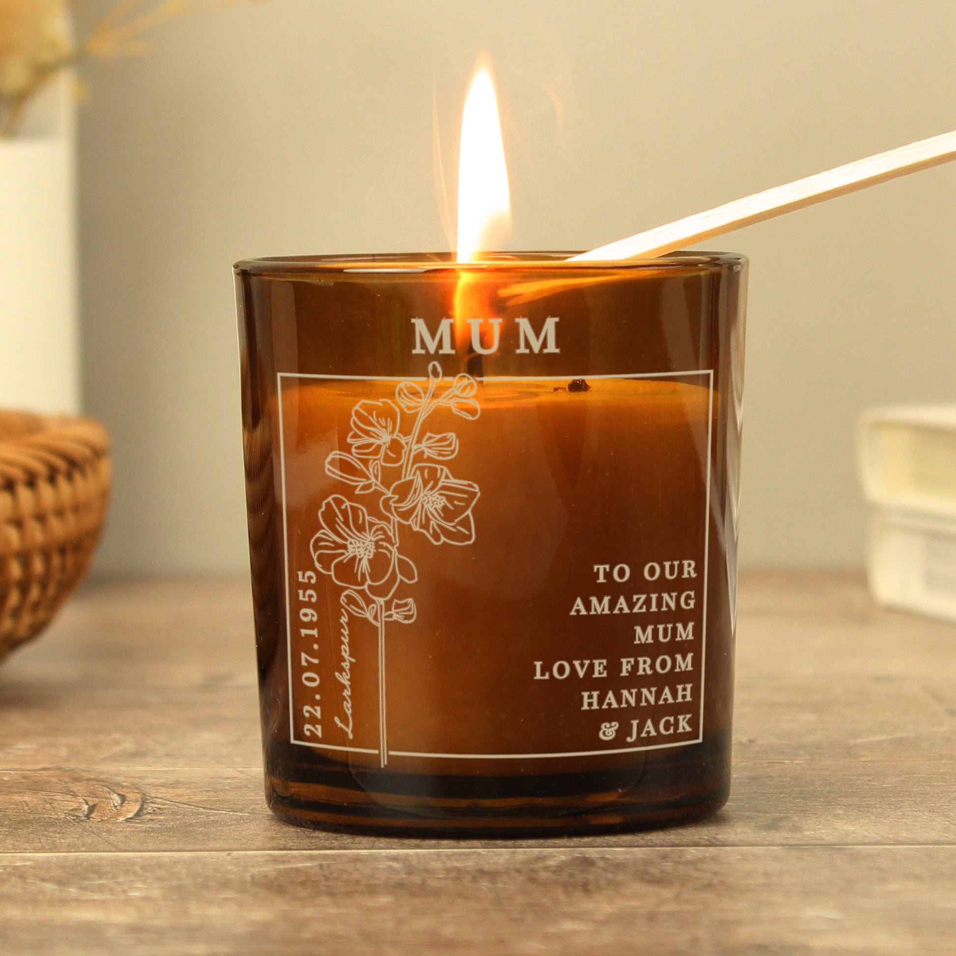 Candle in an amber colour glass container and label with a picture of July’s Birth Flower and space for a personalised name and message 