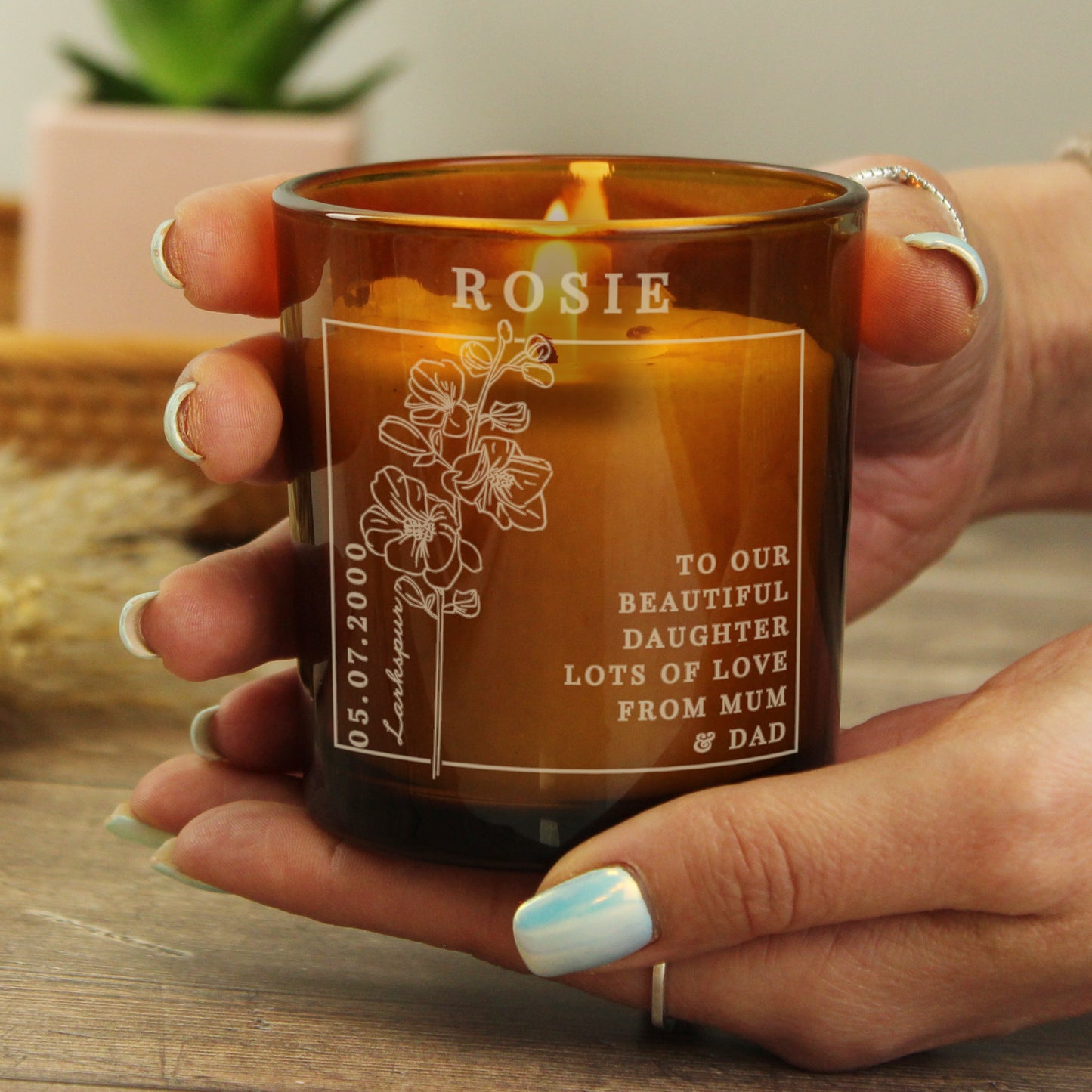 Candle in an amber colour glass container and label with a picture of July’s Birth Flower and space for a personalised name and message 