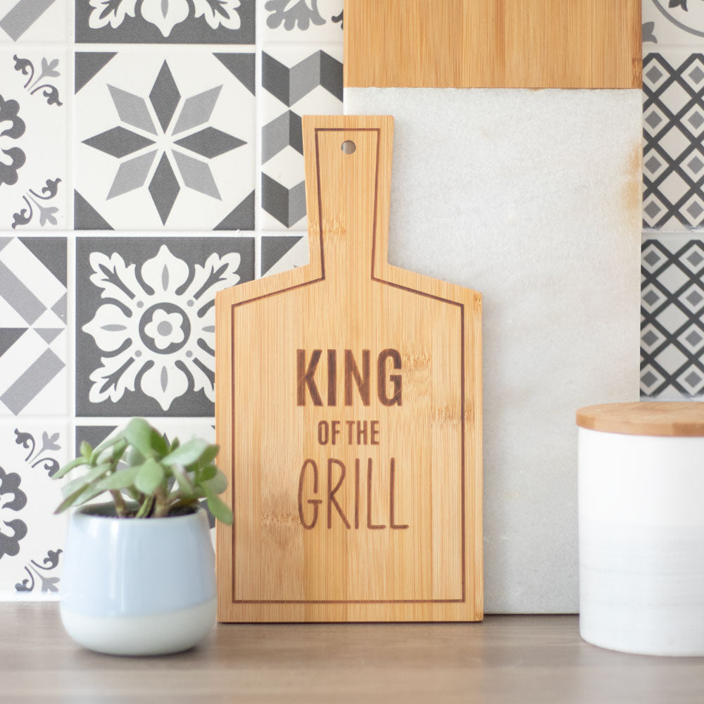 A bamboo serving board featuring the words ‘king of the grill’