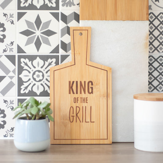 A bamboo serving board featuring the words ‘king of the grill’